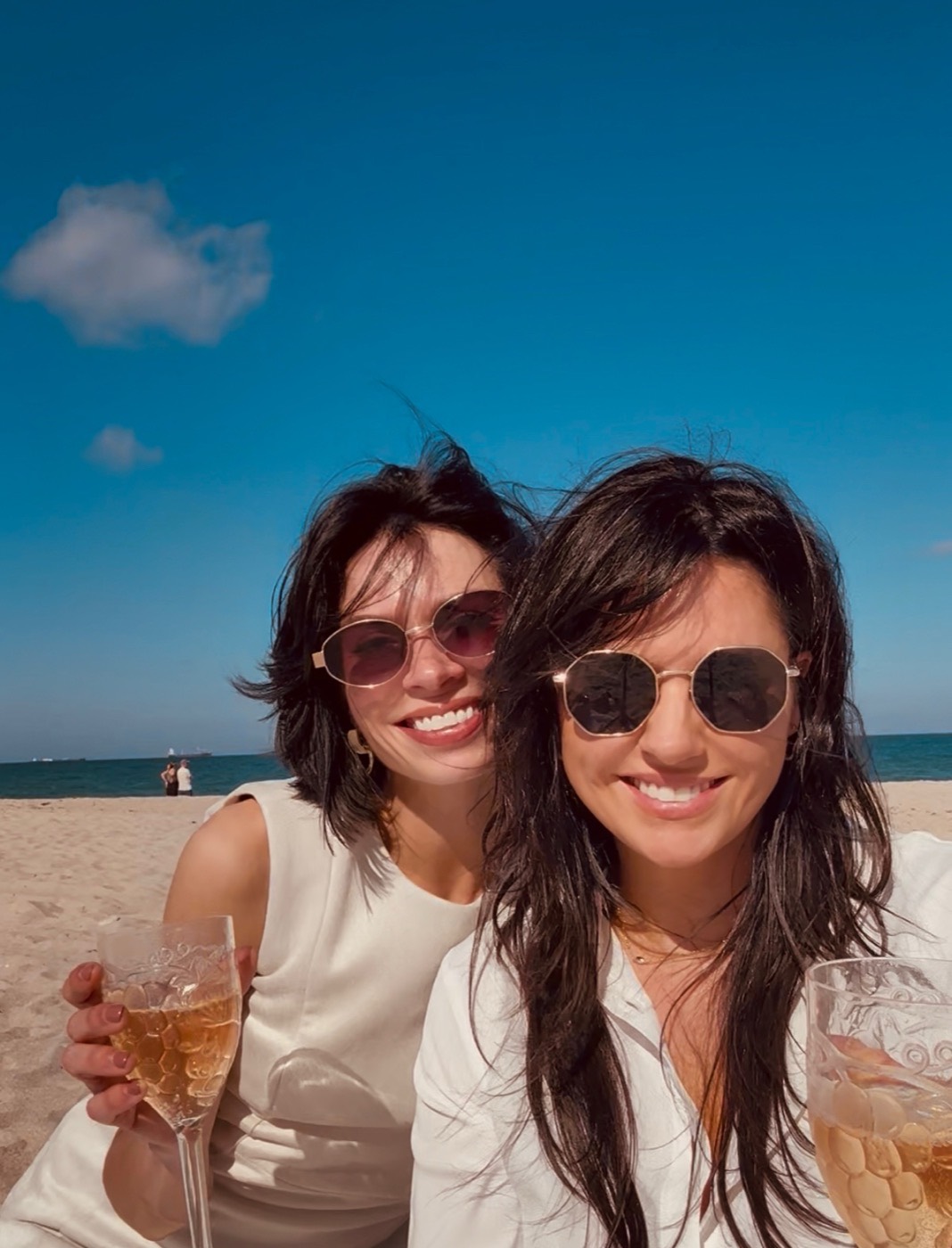 The two Catalina founders on the beach, smiling, holding glasses of champagne